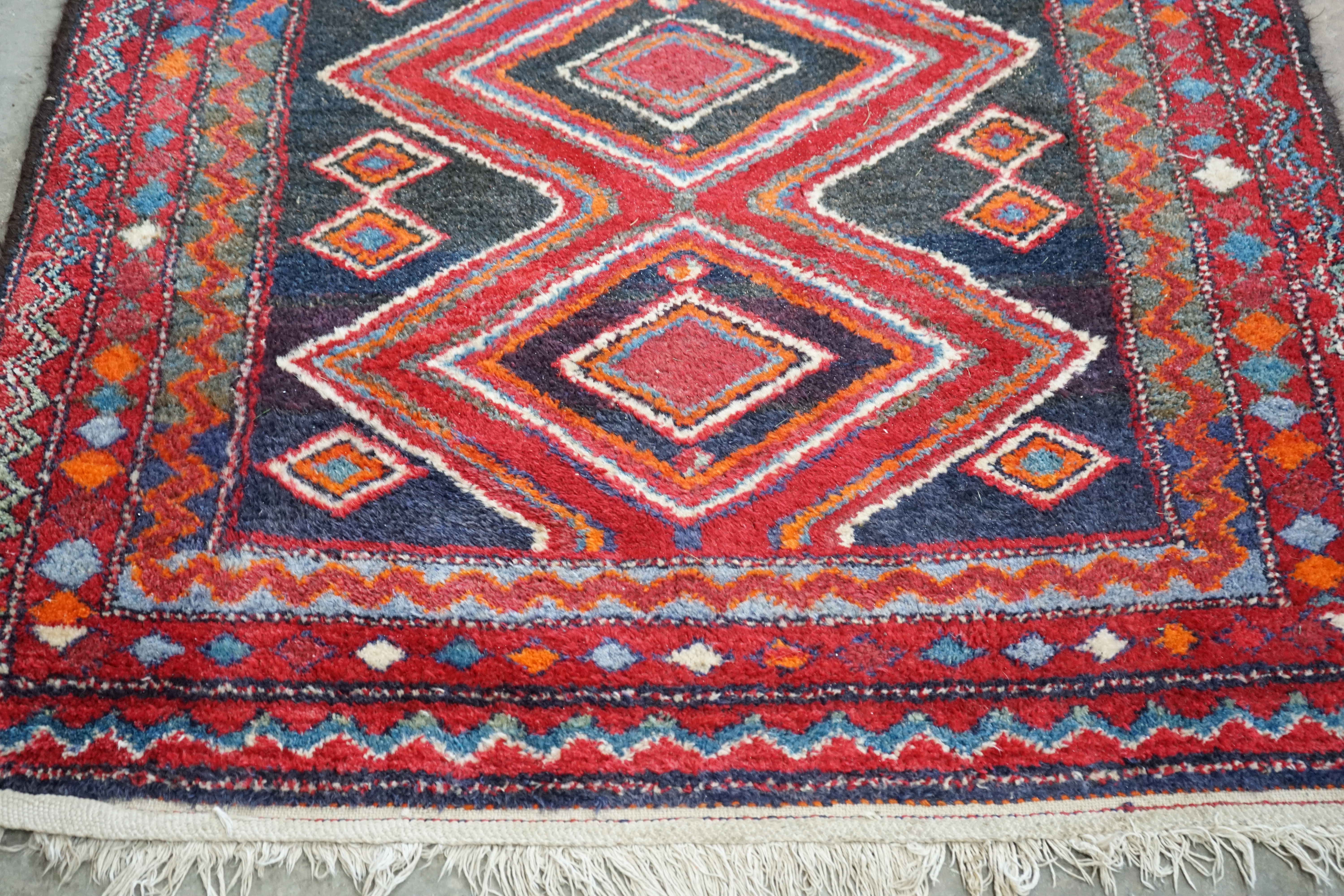 A Belouch blue and red ground rug, 256 x 116cm